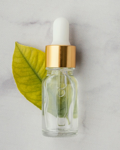 Free Photo top view serum bottle and leaf