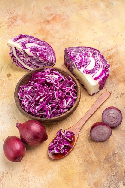 Top view several red onions and chopped red cabbage in a wooden bowl for beet salad on a wooden background with copy place