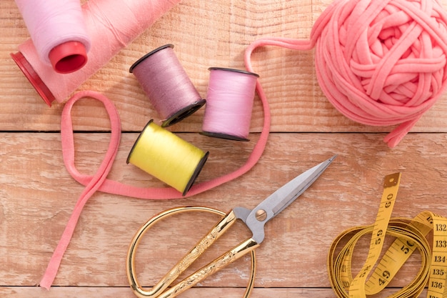 Free photo top view of sewing thread with measuring tape and scissors