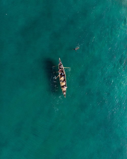 Top view shot of people in a boat fishing in Varkala Beach