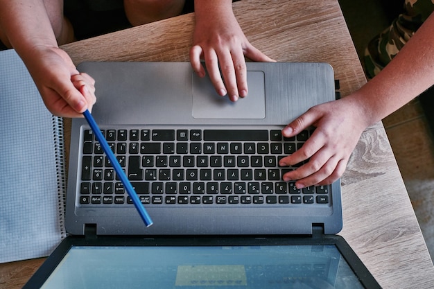 Top view shot of two men's hands discussing the new project and working with laptop