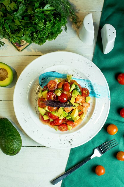 Top view of shrimp salad with avocado and cherry tomatoes in a bowl