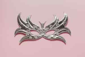 Free photo top view silver mask on pink background