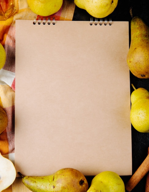 Free photo top view of a sketchbook and fresh ripe pears on black background