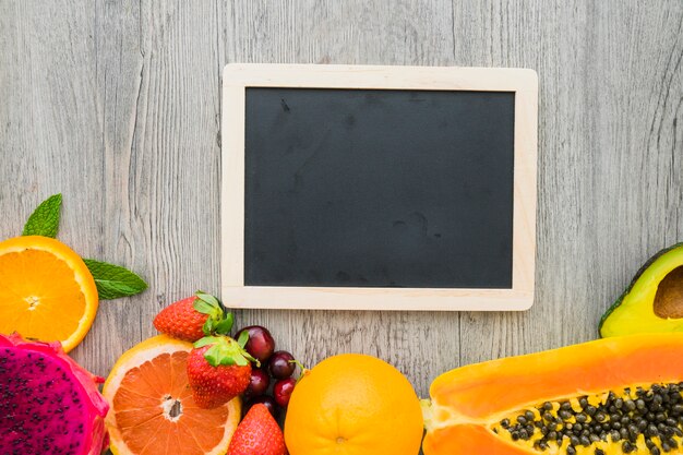 Top view of slate for messages and summer fruits