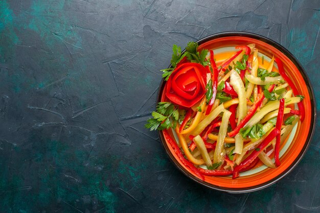 Top view sliced bell peppers different colored salad inside plate on dark background