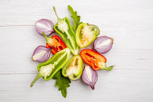 Top view sliced bell-peppers with onions on the white table