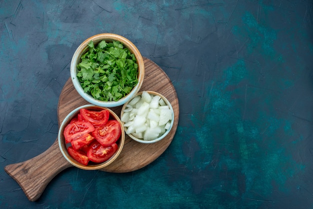 Free Photo top view sliced fresh vegetables tomatoes and onions with greens on dark-blue desk food dinner meal vegetable dish