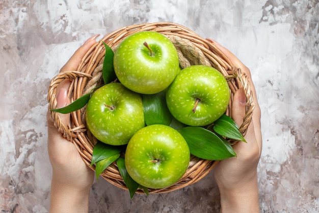 Top view sliced green apples inside basket on light background