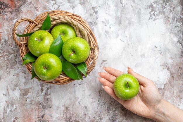 Top view sliced green apples inside basket on light background