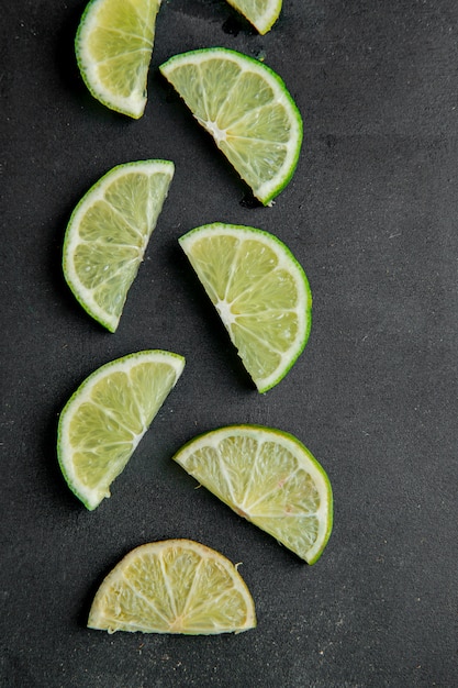 Free photo top view of sliced limes on black surface