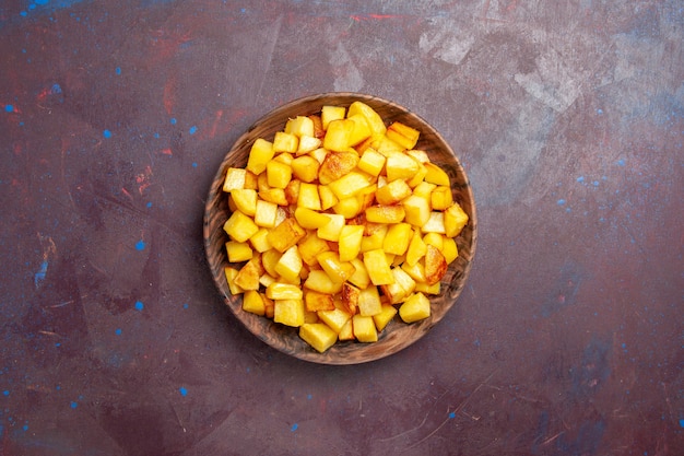 Top view sliced potatoes inside brown plate on a dark