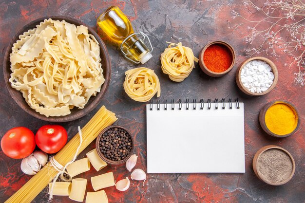 Free photo top view sliced raw dough with seasonings on dark surface pasta dough food