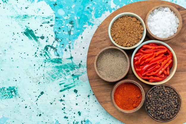 Free photo top view sliced red pepper with seasonings on the blue background salt pepper color photo