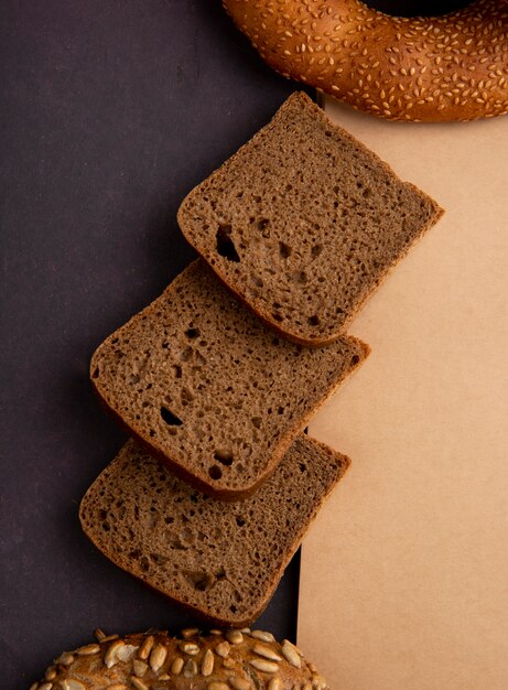 Top view of sliced rye bread on maroon background with copy space