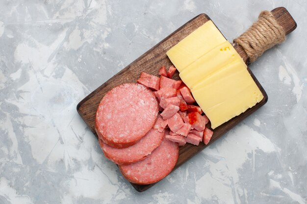 Top view sliced sausages with cheese on white