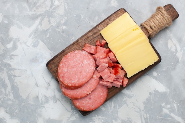 Top view sliced sausages with cheese on white