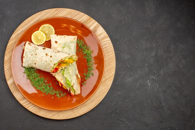 Free photo top view of sliced shaurma delicious meat sandwich inside brown plate on black