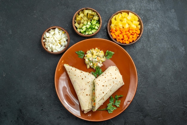 Top view sliced shaurma tasty meat and salad sandwich on grey surface burger pita salad sandwich bread