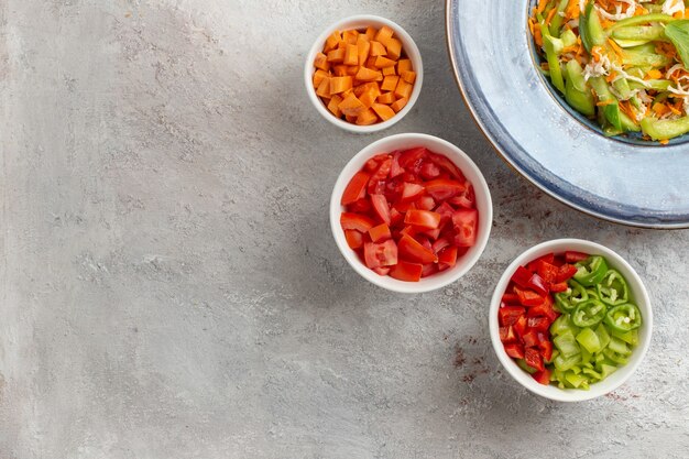 Top view sliced vegetable salad inside plate on light-white desk