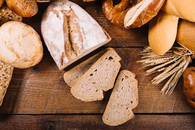 Free photo top view of sliced wholegrain bread on wooden table