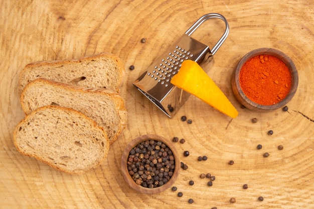 Free Photo top view slices of bread cheese grater different spices in small bowls on wooden table