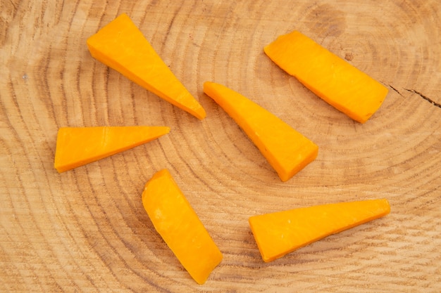 Top view slices of cheese on wooden table