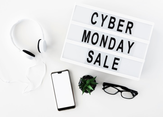 Free photo top view of smartphone with glasses and headphones for cyber monday