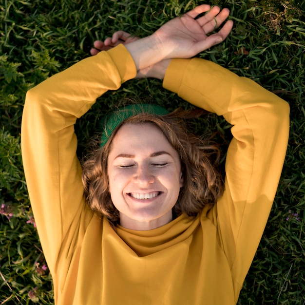 Top view smiley girl staying on the grass