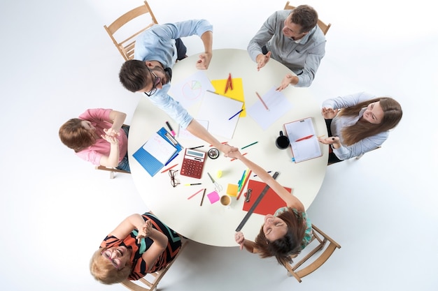 Free photo top view of smilimg business team, sitting at a round table on white background. concept of successful transaction