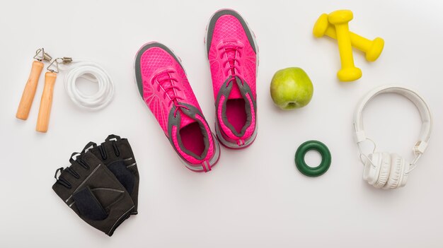 Top view of sneakers with gym gloves and headphones