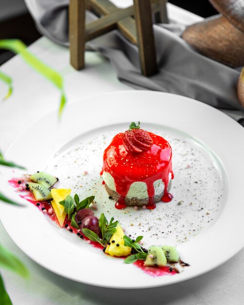 Top view souffle with strawberry icing with fruit decor on a plate