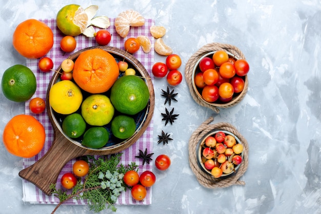 Free photo top view sour fresh tangerines with lemons and plums on light-white desk