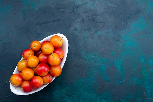 Free photo top view of sour plums inside plate on dark-blue surface