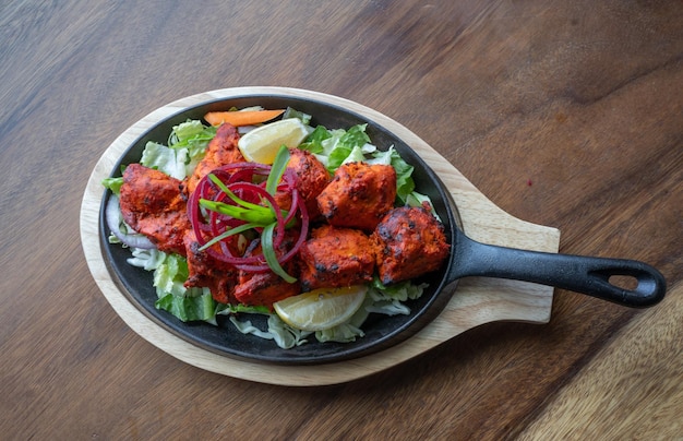 Free photo top view of spicy chicken with lettuce and lemon in a pan on the table