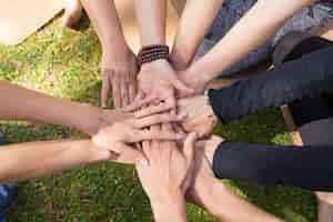 Free photo top view of stack of hands against green grass