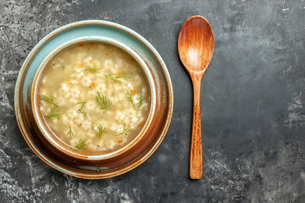 Top view star soup in bowl wooden spoon on dark background