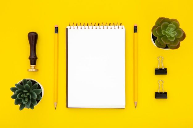 Free Photo top view stationery arrangement on yellow background