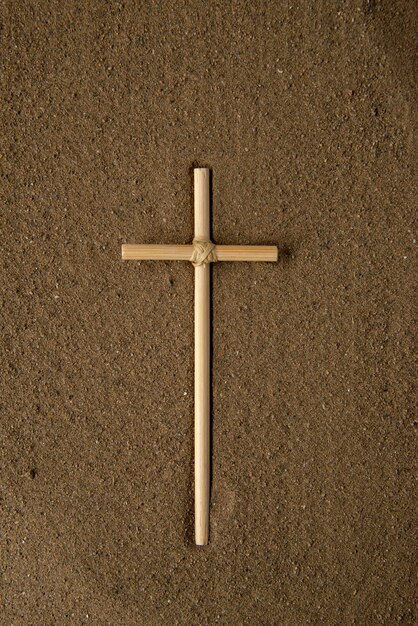 Top view of stick cross on brown sand