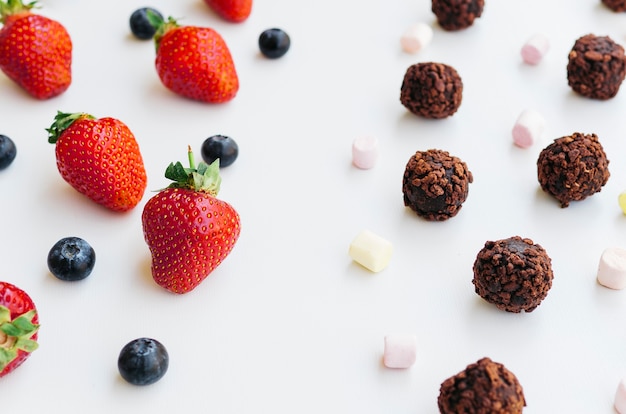 Free photo top view strawberries vs chocolates