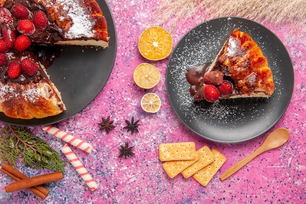 Top view strawberry chocolate cake with   and crackers on pink surface