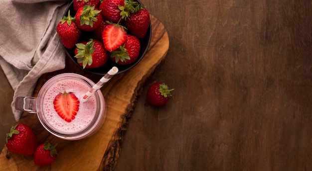 Free photo top view of strawberry milkshake with straw and copy space