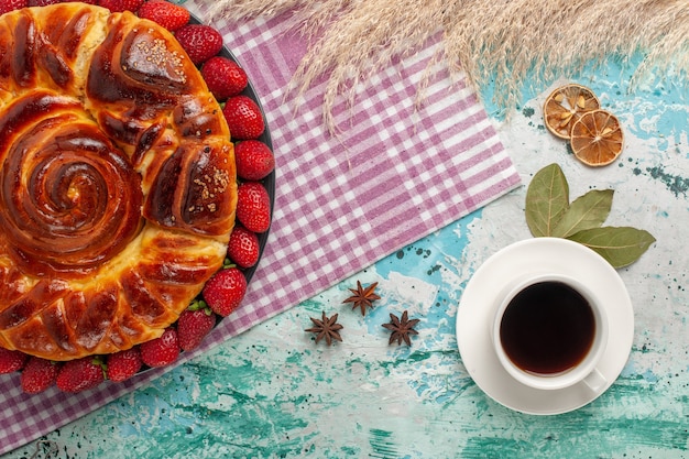 Top view strawberry pie with cup of tea on blue surface