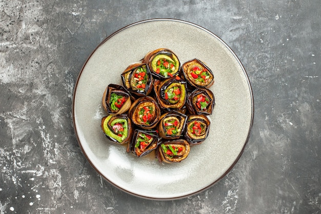 Free Photo top view stuffed aubergine rolls on plate on grey surface