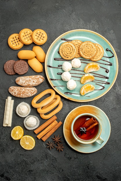 Free photo top view sugar cookies with candies cup of tea on grey background