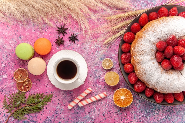 Top view sugar powdered pie strawberry cake with cup of tea on a pink