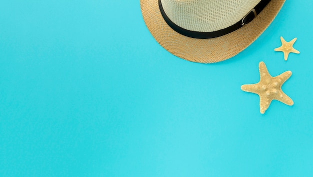 Free photo top view summer hat and starfish with copy space