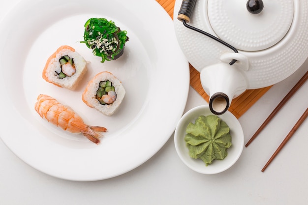 Top view sushi rolls with wasabi on the table