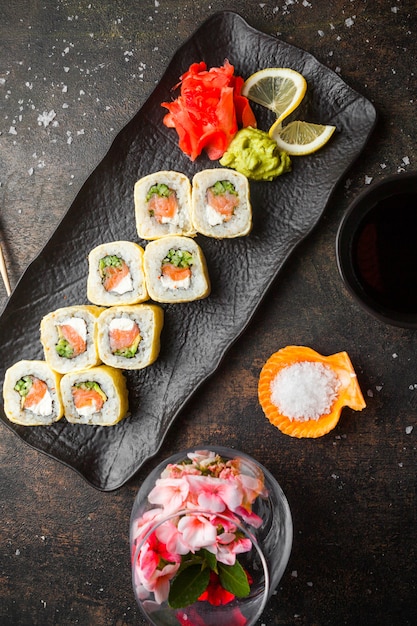 Top view sushi set with pickled ginger and wasabi and soy sauce in dark plate