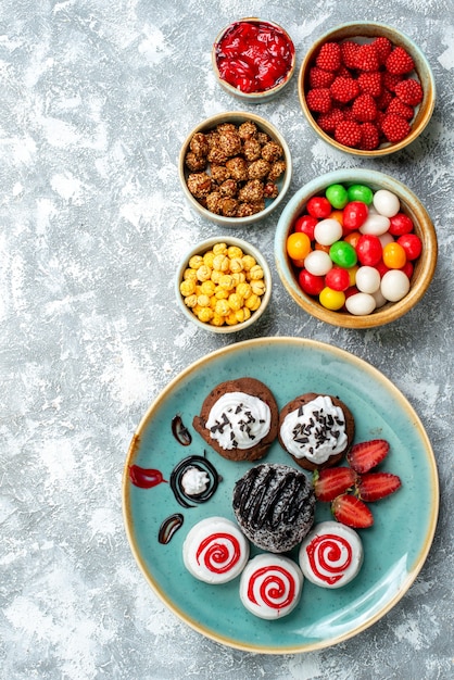 Free photo top view sweet biscuits with chocolate cake and candies on light-white background candy sugar biscuit cake sweet tea